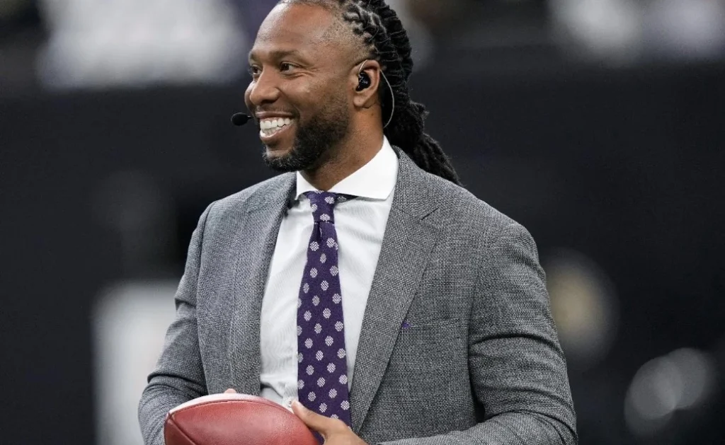 larry fitzgerald jr. holds a ball on the field before a game