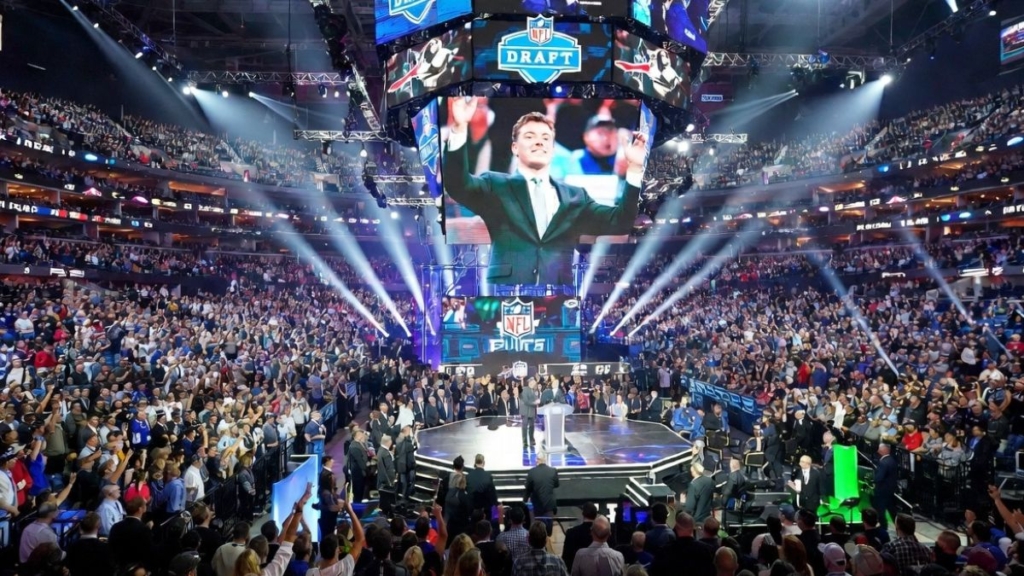 The 2026 NFL Draft stage illuminated in bright neon lights waiting for the first overall pick.