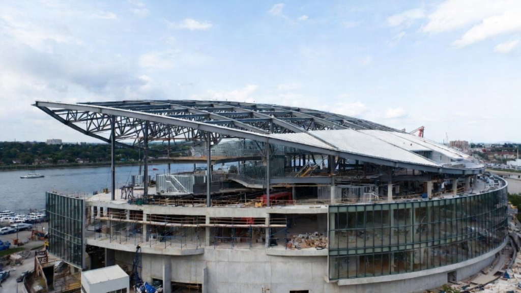 wide angle shot of the massive draft theater being built on the north shore of the allegheny river - Image Credit: NHANFL / AI-Generated